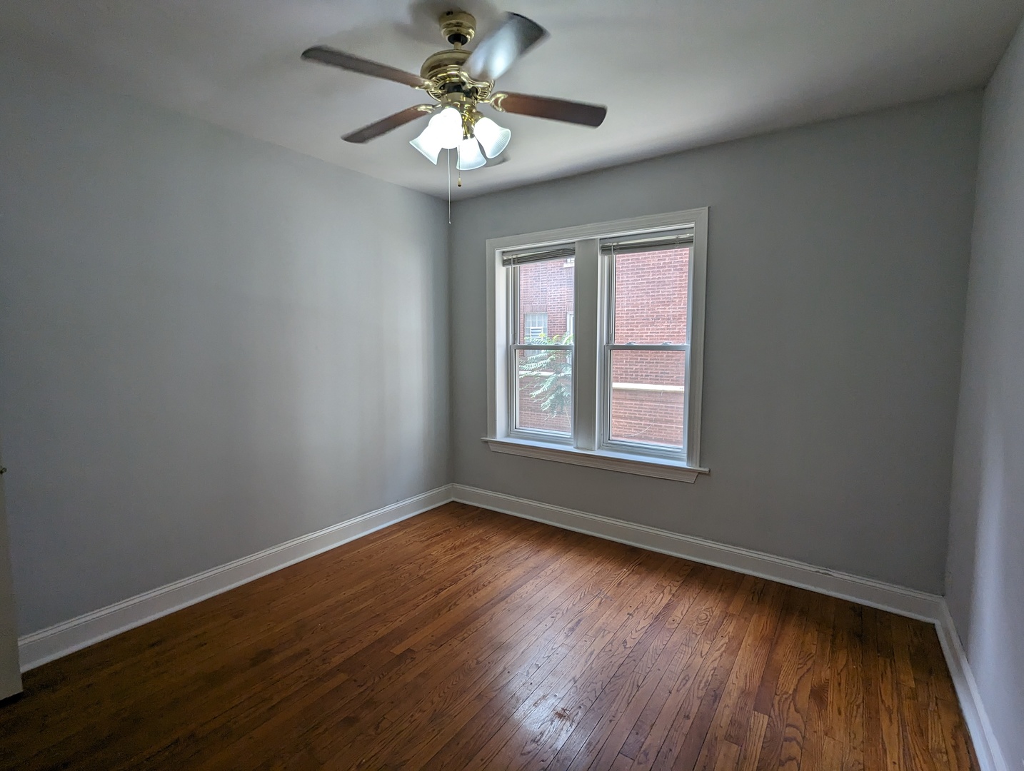 5029 North Harding Avenue, Unit 1W Chicago, IL 60625 - Photo 18 of 18 a view of an empty room with wooden floor and a window