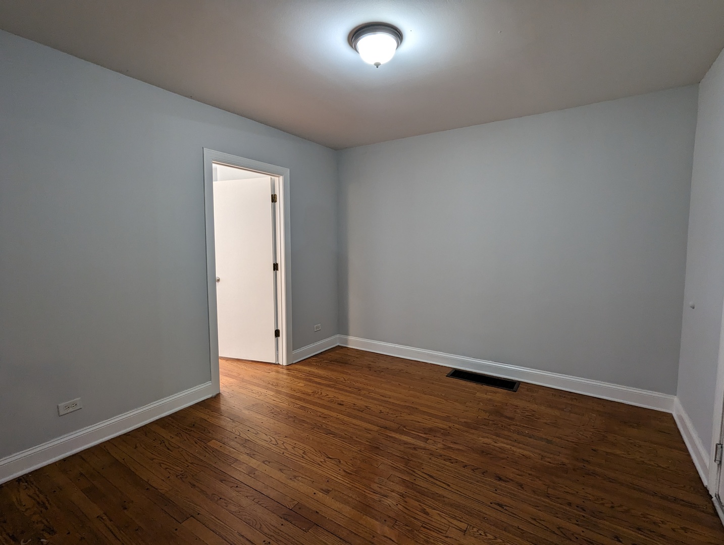 5029 North Harding Avenue, Unit 1W Chicago, IL 60625 - Photo 2 of 18 a view of an empty room with wooden floor and closet