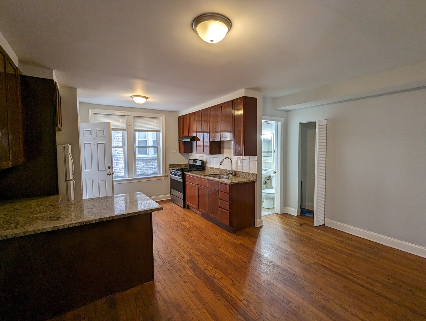 5029 North Harding Avenue, Unit 1W Chicago, IL 60625 - Photo 8 of 18 a kitchen with stainless steel appliances granite countertop a stove a sink a refrigerator and a microwave