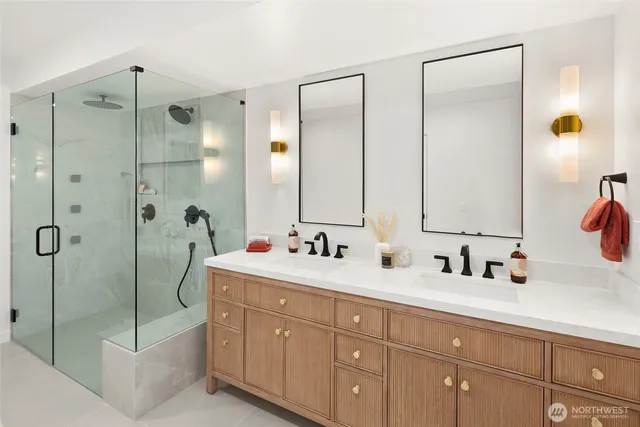 a bathroom with double vanity and a mirror