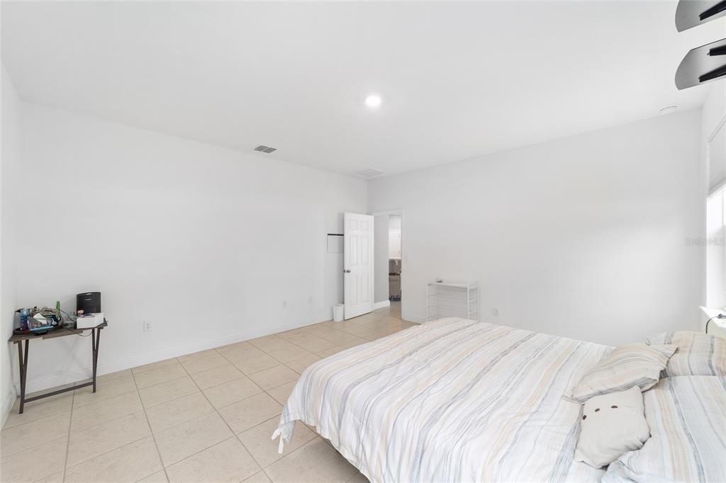 11102 Southwest 58th Avenue Road Ocala, FL 34476 - Photo 36 of 47 a bedroom with a bed and a lamp on the dresser