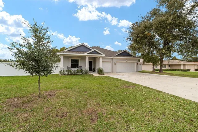 a living room with furniture white walls and kitchen view