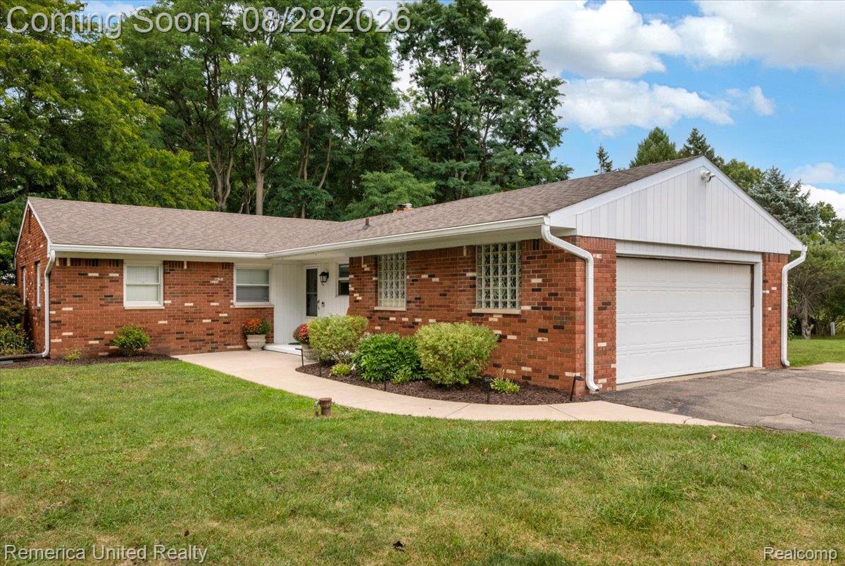 3687 Van Amberg Road Brighton, MI 48114 - Photo 44 of 56 Brick exterior featuring a two-car garage, concrete driveway, and a paved walkway