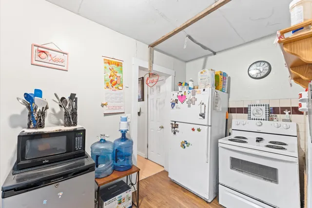 a white refrigerator freezer sitting inside of a kitchen with stainless steel appliances kitchen island a refrigerator and a stove