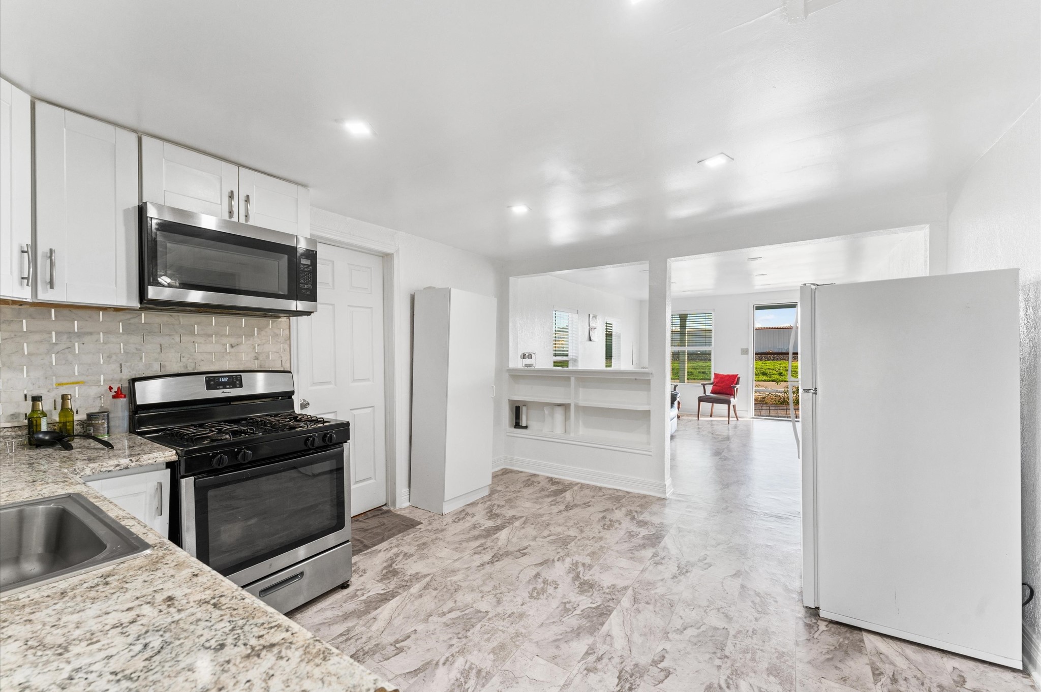 1605 Walnut Avenue Rosenberg, TX 77471 - Photo 20 of 29 a kitchen with granite countertop a refrigerator and a stove top oven
