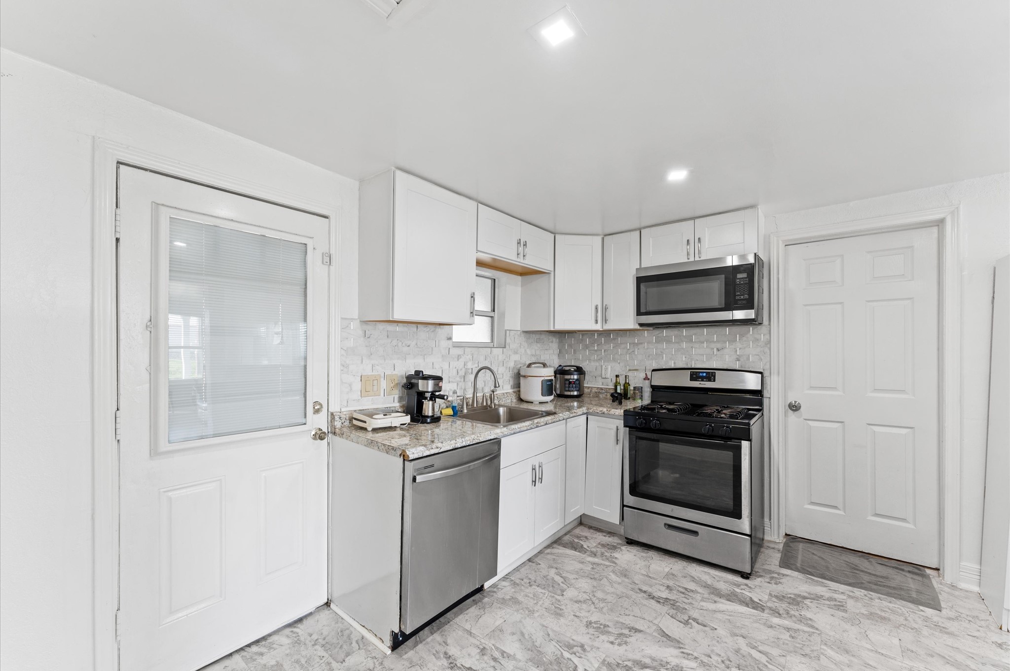 1605 Walnut Avenue Rosenberg, TX 77471 - Photo 7 of 29 a kitchen with stainless steel appliances granite countertop a stove a sink and a refrigerator