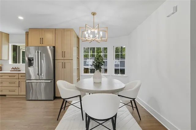 a view of a dining room with furniture a chandelier and wooden floor