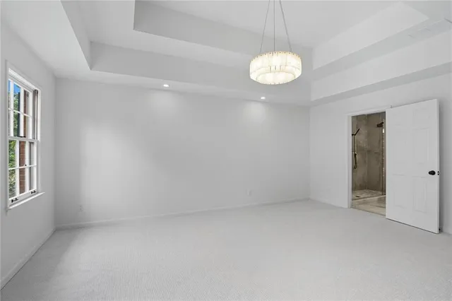 an empty room with windows and chandelier fan