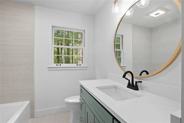 a bathroom with a sink a toilet and a mirror