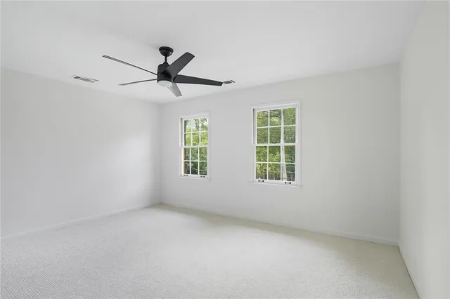 an empty room with a window and a fan