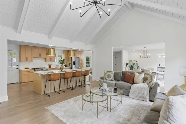 a living room with lots of furniture and view of kitchen