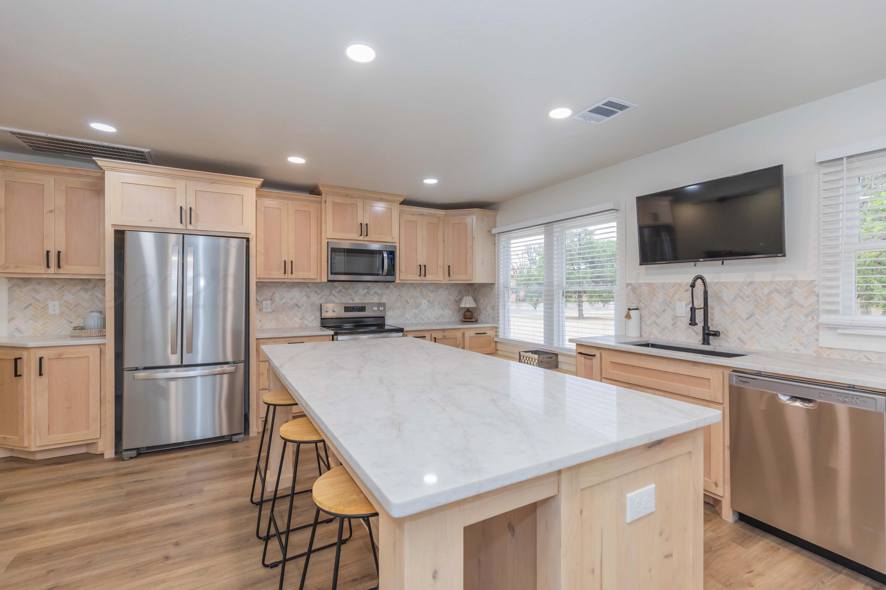 504 High Street Claude, TX 79019 - Photo 20 of 39 a kitchen with kitchen island a sink appliances and cabinets