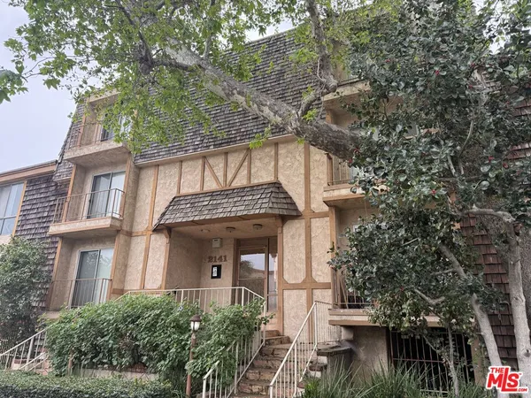a front view of a house with a tree