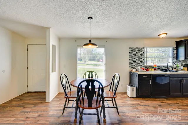 a dining room with furniture a chandelier and wooden floor