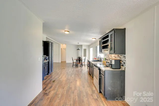 a kitchen with stainless steel appliances granite countertop a lot of cabinets and wooden floor