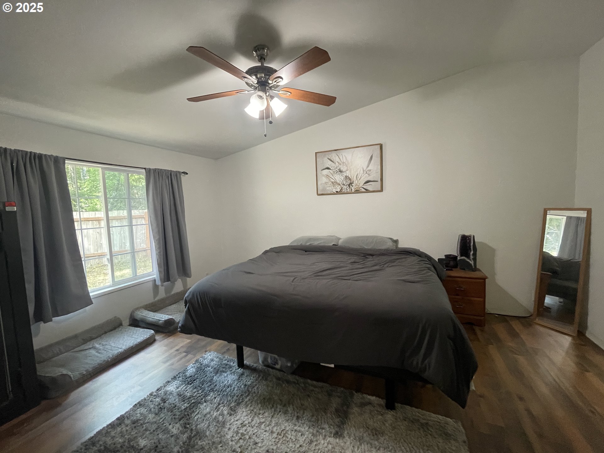 56129 Tom Smith Road Bandon, OR 97411 - Photo 7 of 27 a bedroom with a bed and a chandelier