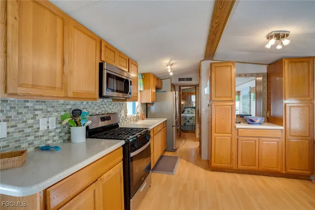 a kitchen with stainless steel appliances granite countertop a refrigerator a stove top oven a sink and dishwasher