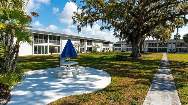 a view of a house with backyard and sitting area