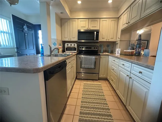 a kitchen with stainless steel appliances a stove sink microwave and cabinets