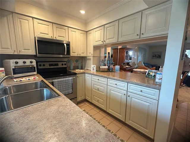 a kitchen with kitchen island granite countertop a sink stove and microwave