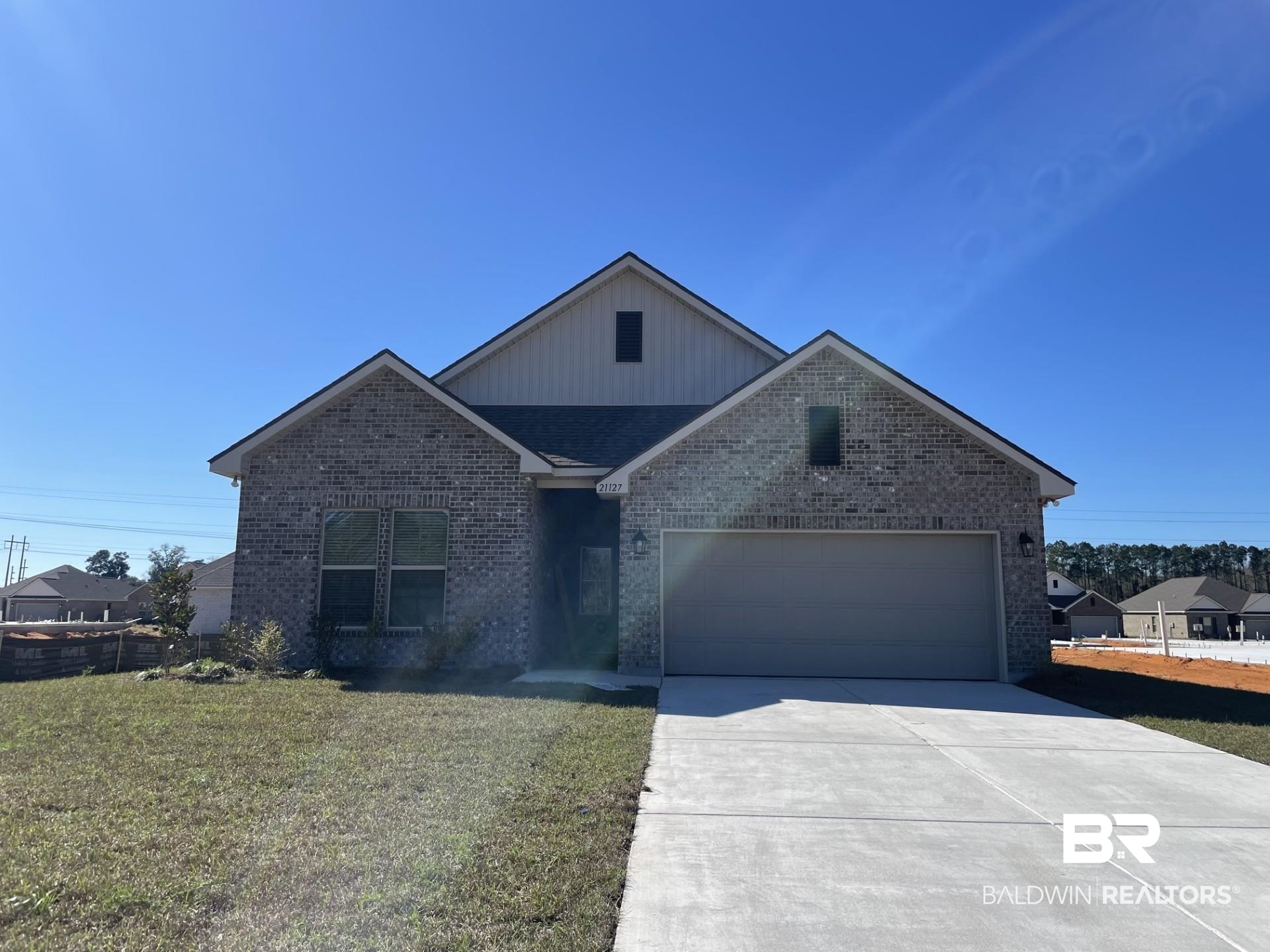 21127 Central Avenue Silverhill, AL 36576 - Photo 1 of 3 View of front facade featuring a garage and a front lawn