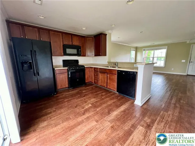 a large kitchen with stainless steel appliances kitchen island granite countertop a refrigerator stove top oven and sink