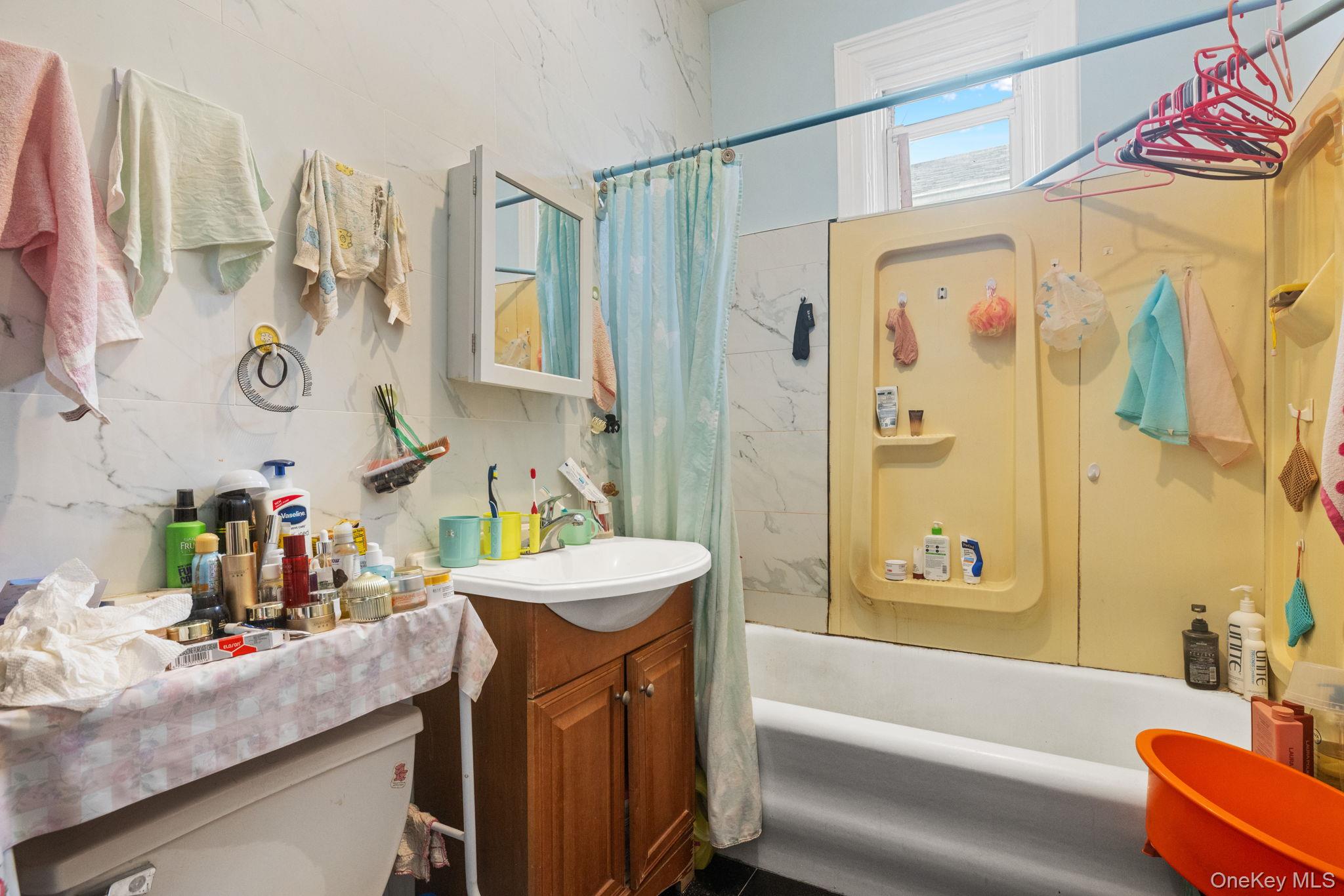 149 Dahill Road Brooklyn, NY 11218 - Photo 10 of 36 a bathroom with a sink mirror toilet and bathtub