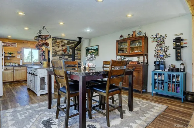 a dining room with stainless steel appliances a table and chairs with the wooden floor