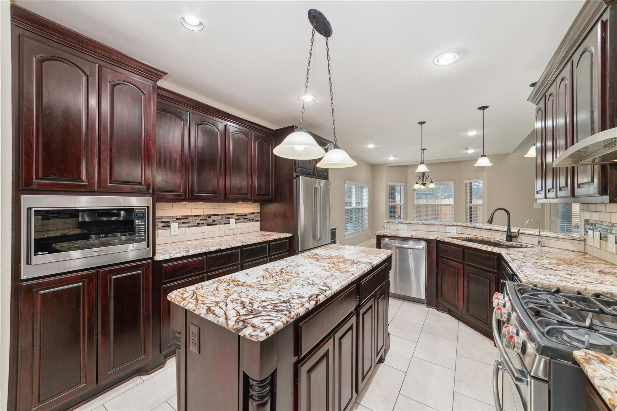 19022 Santa Elena Canyon Court Spring, TX 77388 - Photo 20 of 38 a kitchen with granite countertop stainless steel appliances and wooden cabinets