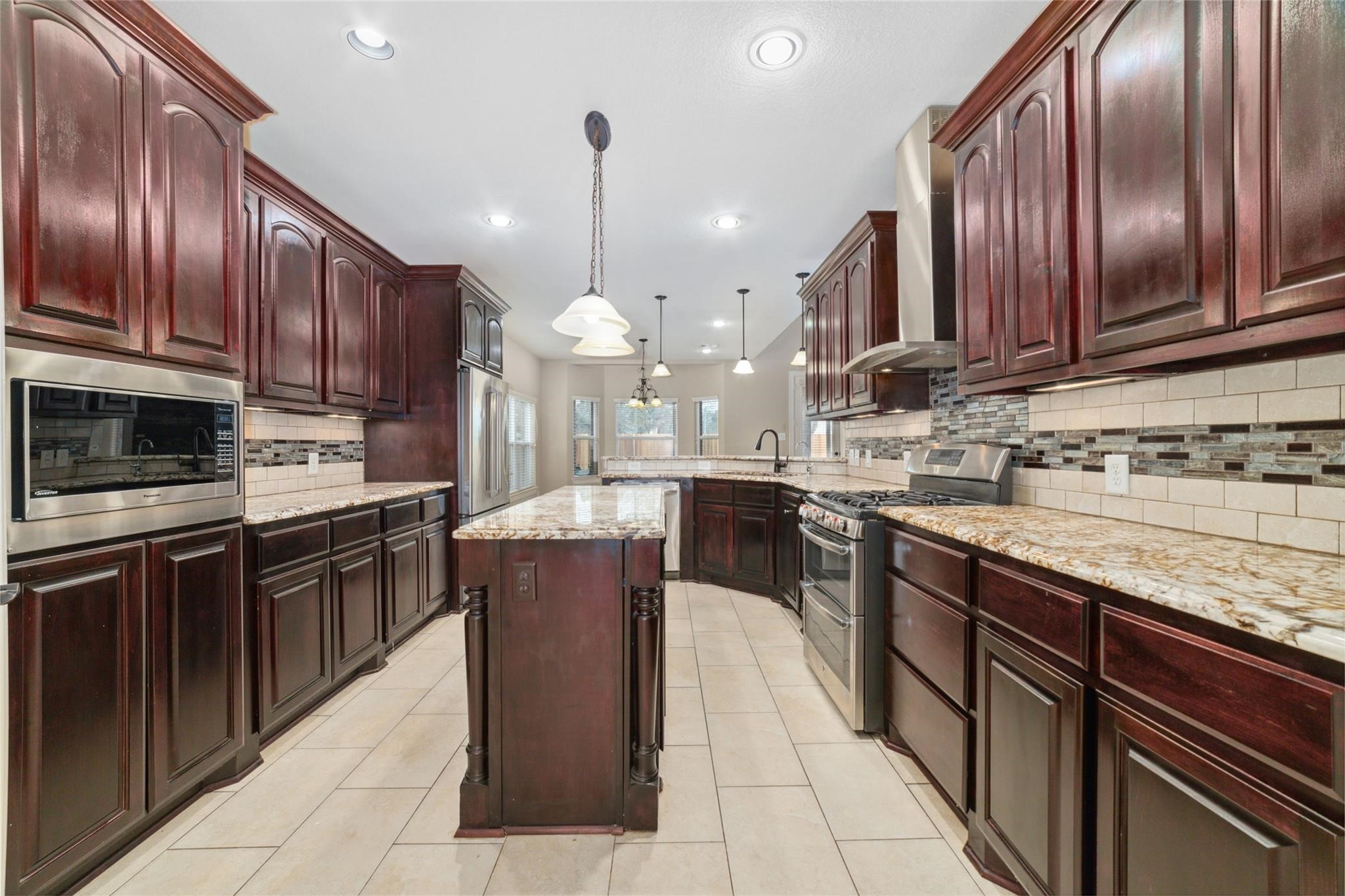 19022 Santa Elena Canyon Court Spring, TX 77388 - Photo 22 of 38 a kitchen with stainless steel appliances granite countertop wooden cabinets a sink and dishwasher