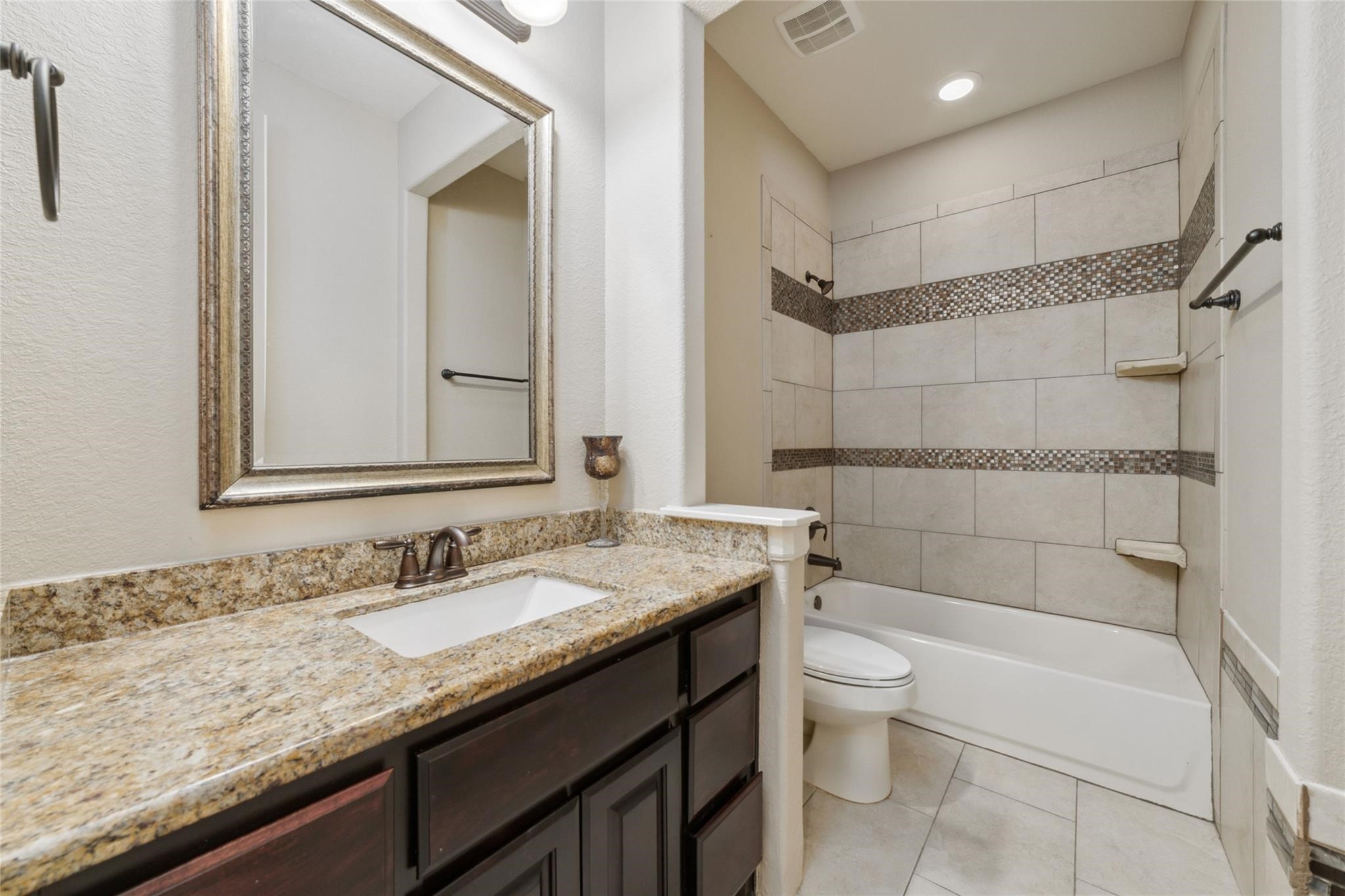 19022 Santa Elena Canyon Court Spring, TX 77388 - Photo 30 of 38 a bathroom with a granite countertop sink a toilet and shower
