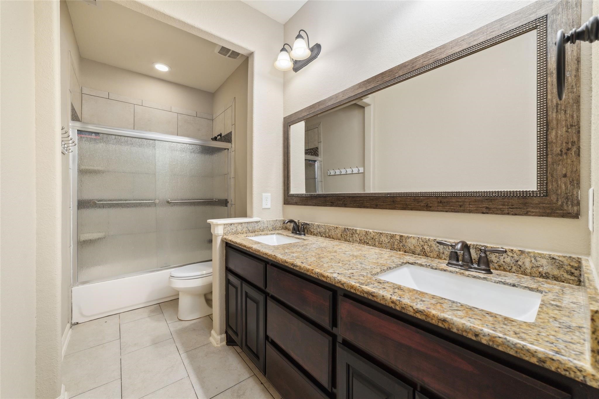 19022 Santa Elena Canyon Court Spring, TX 77388 - Photo 32 of 38 a bathroom with a granite countertop sink a toilet and shower