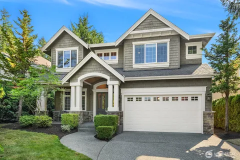 a view of small white house with a small yard and potted plants