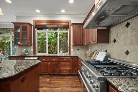 a kitchen with stainless steel appliances granite countertop a stove a sink and a microwave