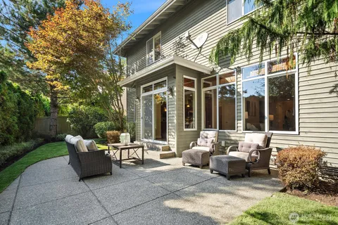 a patio with a table and chairs and potted plants