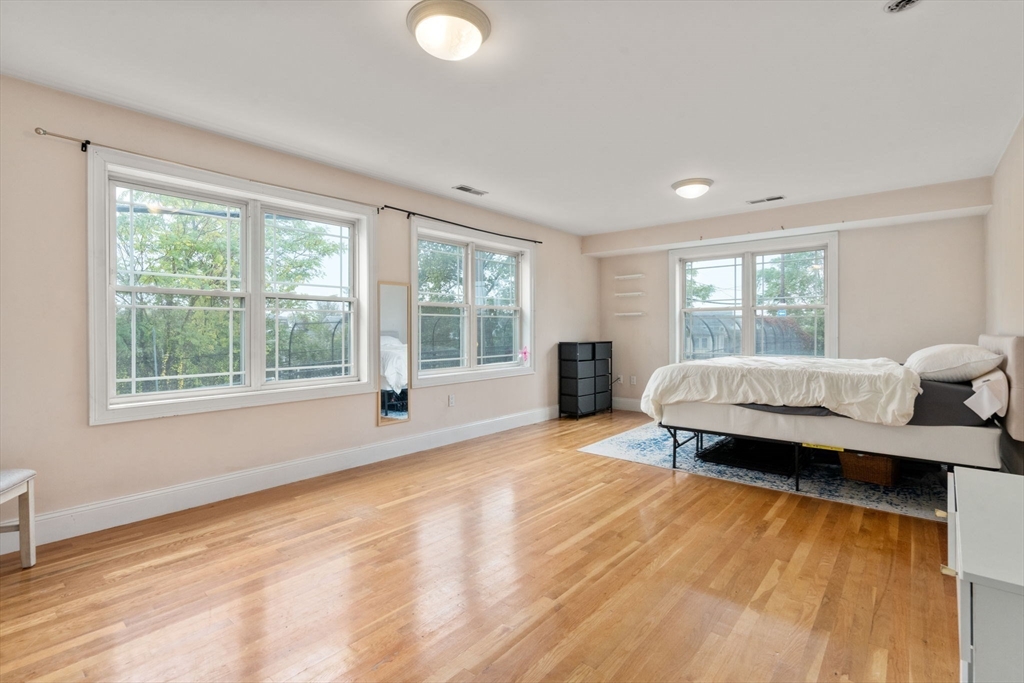 62 Redfield Street, Unit 62 Boston, MA 02122 - Photo 14 of 30 a spacious bedroom with a large window and a wooden floor