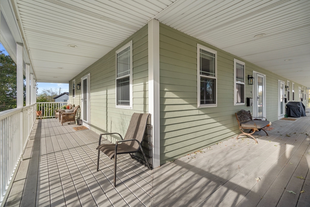 62 Redfield Street, Unit 62 Boston, MA 02122 - Photo 24 of 30 a view of a patio with table and chairs with wooden floor and fence