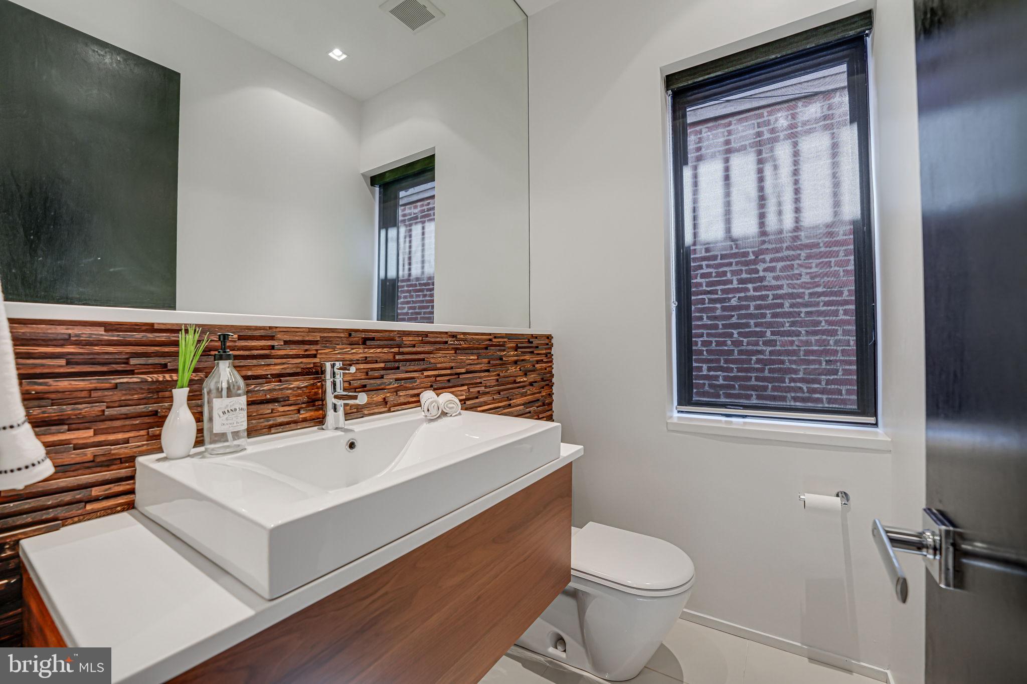 1836 9th Street Northwest, Unit 2 Washington, DC 20001 - Photo 22 of 30 a bathroom with a sink a toilet and mirror