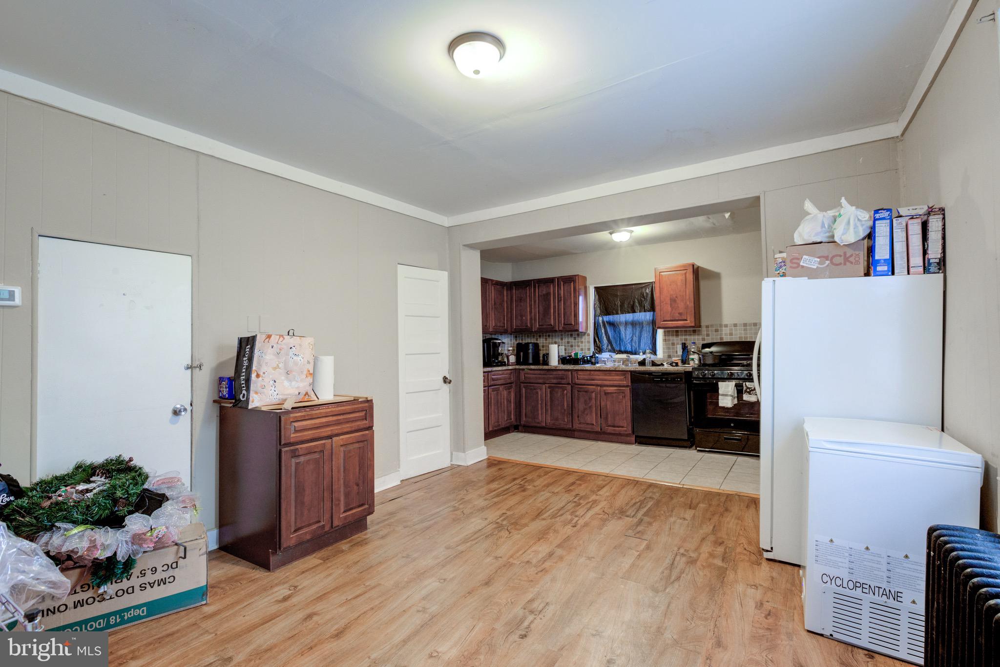 6209 Carpenter Street Philadelphia, PA 19143 - Photo 19 of 44 a kitchen with stainless steel appliances kitchen island wooden floors and refrigerator