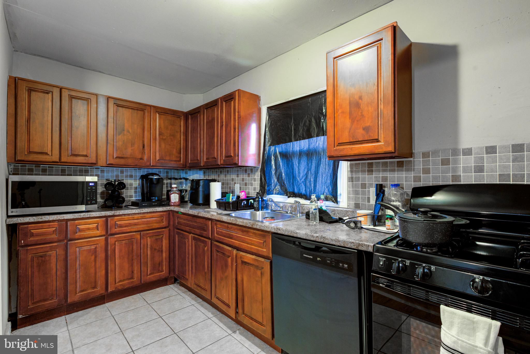 6209 Carpenter Street Philadelphia, PA 19143 - Photo 22 of 44 a kitchen with a sink a stove and cabinets