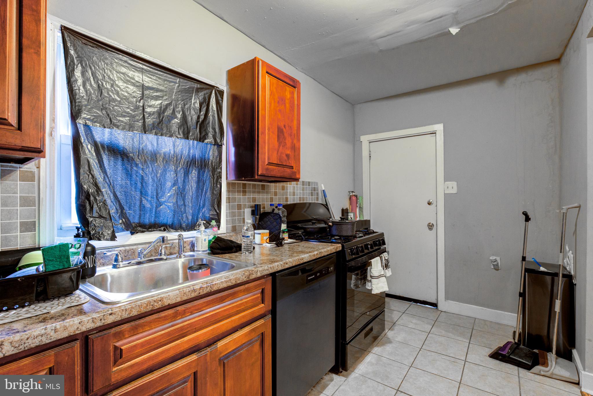 6209 Carpenter Street Philadelphia, PA 19143 - Photo 23 of 44 a kitchen with a sink stove and cabinets