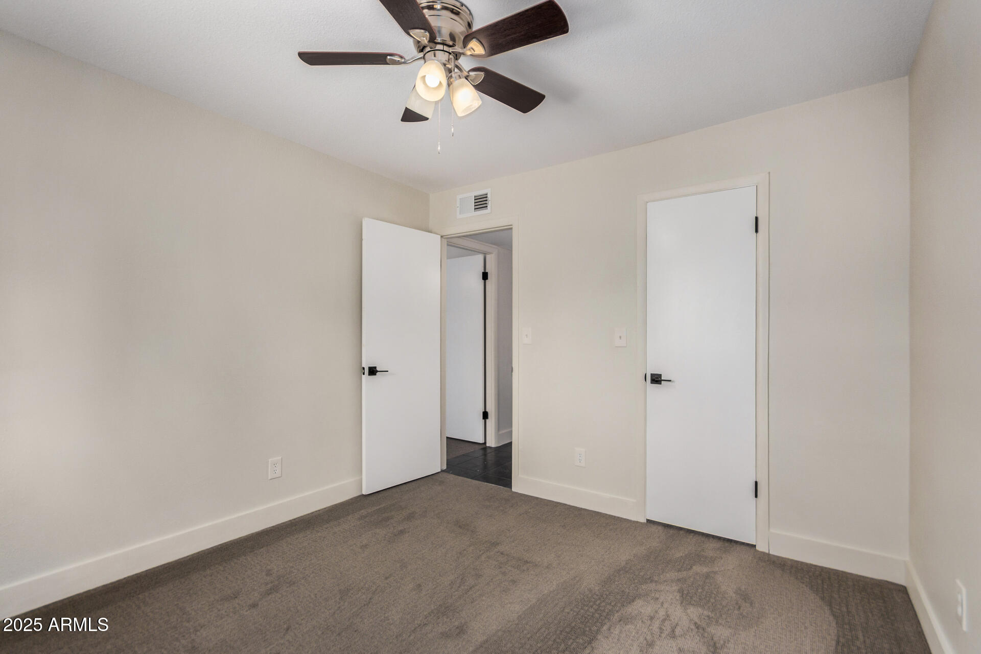 7126 North 19th Avenue, Unit 169 Phoenix, AZ 85021 - Photo 20 of 30 an empty room with a chandelier fan and windows