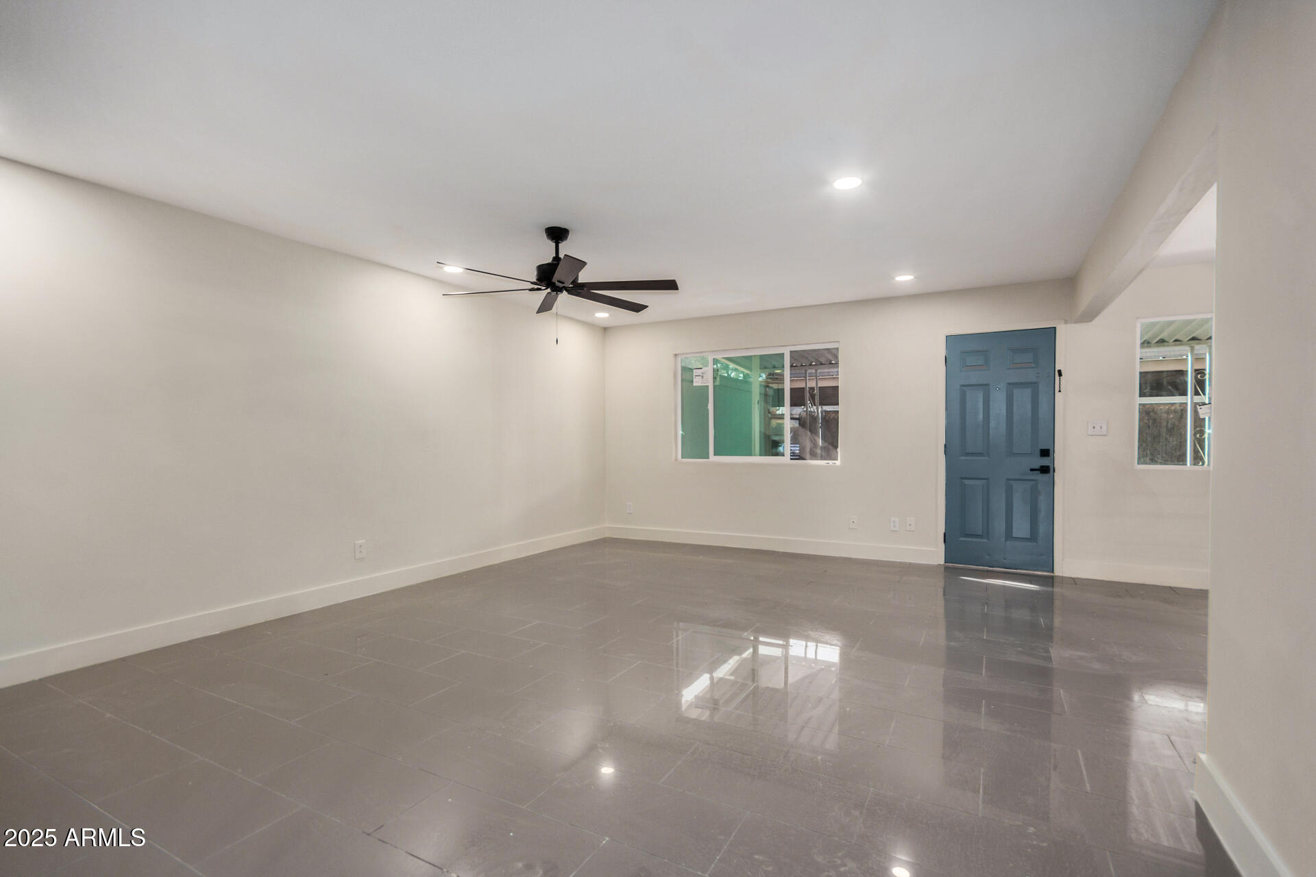 7126 North 19th Avenue, Unit 169 Phoenix, AZ 85021 - Photo 5 of 30 a view of empty room with wooden floor and fan