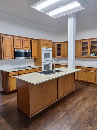 a bathroom with a granite countertop sink and mirror with window