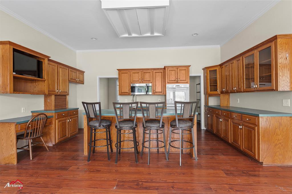 15280 Wynn School Road Hosston, LA 71043 - Photo 7 of 27 Kitchen featuring stainless steel microwave, dark wood-type flooring, and brown cabinets
