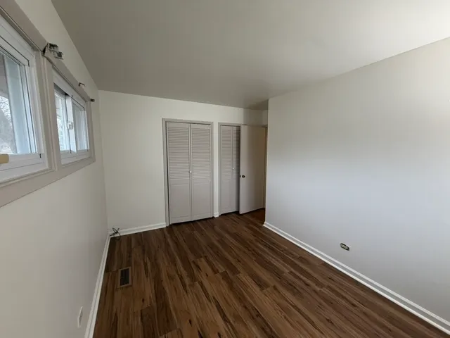 a view of an empty room and wooden floor