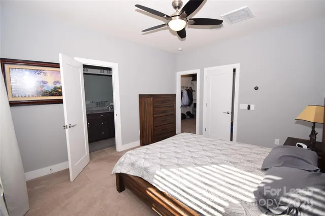 a bedroom with a bed and a ceiling fan