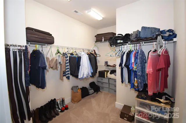 a view of walk in closet with clothes and shoes