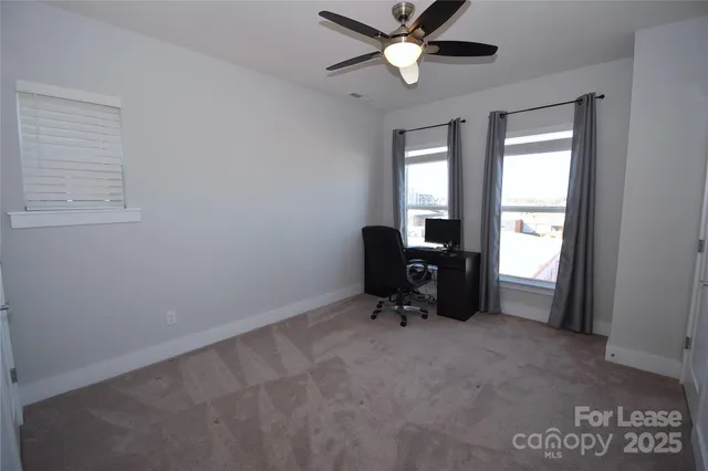 a view of a workspace with furniture and a window