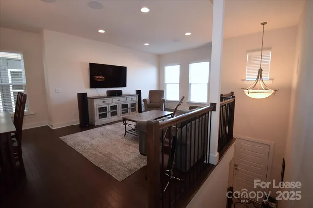 a living room with furniture a flat screen tv and a table